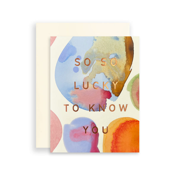 Moglea marble lucky card featuring a swirl of white, gray, and beige marble patterns with gold accents.
