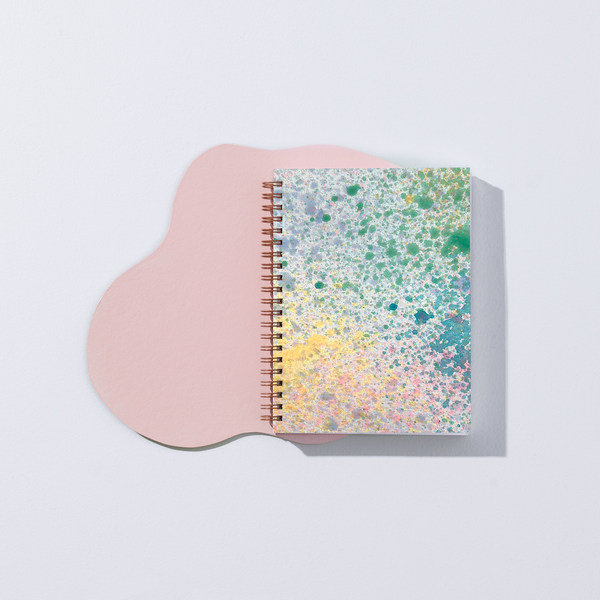 Painted Mystic Journal notebook by Moglea with vibrant, abstract cover art and textured pages for creative writing and sketching.